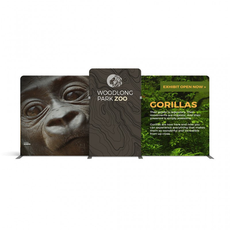 The 20ft Waveline Media M-Series Kit 06 by Affordable Exhibit Displays features three panels for Woodlong Park Zoo: a gorilla close-up, the zoo’s logo, and a gorilla exhibit announcement with green foliage on a sleek tension fabric display.