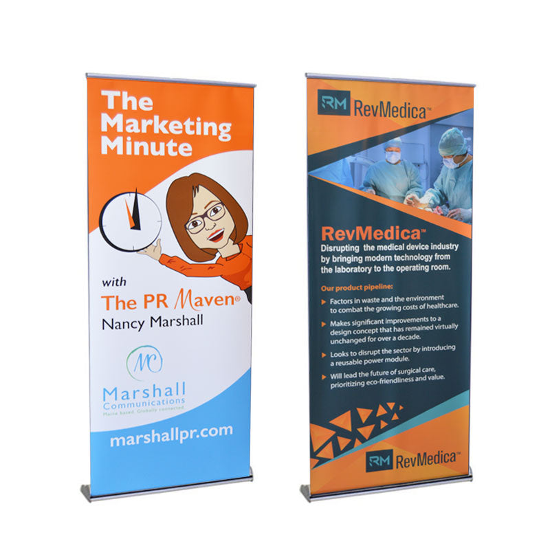 Two Orient Standard Retractable Banner Stands: one orange with The Marketing Minute's cartoon woman graphic for Nancy Marshall, and one blue/orange single-sided RevMedica banner featuring surgeons and medical technology text.