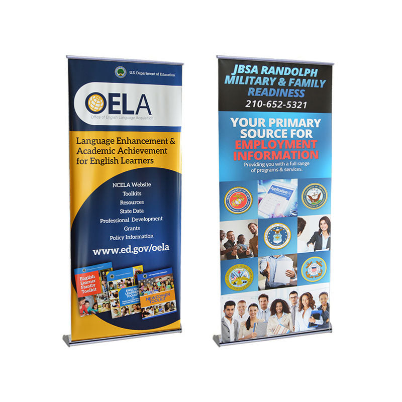 Two vertical Orient Standard Retractable Banner Stands: the left with OELA’s Language Enhancement graphics for English learners, and the right displaying JBSA Military & Family Readiness employment info, contact details, and photos of people.