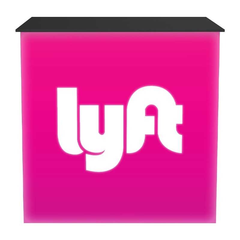 The Embrace Tension Fabric Light Box Counter by Affordable Exhibit Displays features a bright pink, collapsible design with the white Lyft logo on the front and a sleek black rectangular top.