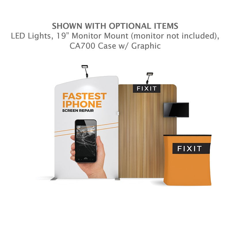 The 10ft Waveline Media M-Series Kit 03 by Affordable Exhibit Displays features a curved fabric display with FASTEST IPHONE SCREEN REPAIR, cracked phone image, branded counter, wood panel with monitor mount, LED lights, and visible FIXIT branding.