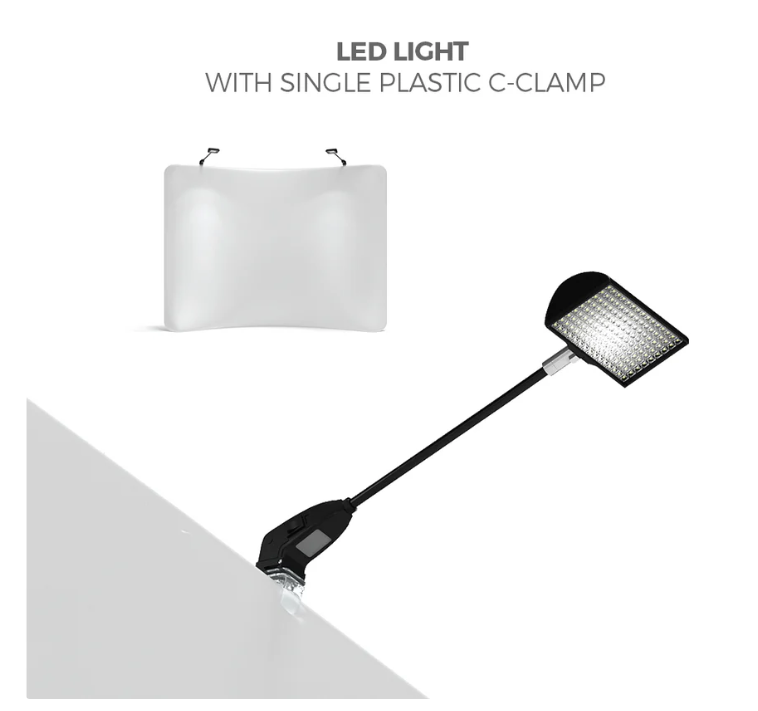 The Affordable Exhibit Displays LED light, featuring a single plastic C-clamp, is perfect for lighting your WaveLine® 6ft Curve Table Top display. Shown under a softly lit white backdrop. Text above: LED LIGHT WITH SINGLE PLASTIC C-CLAMP.