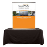 A table top banner stand on a black table on a white background. 