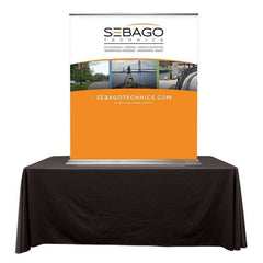 A table top banner stand on a black table on a white background. 